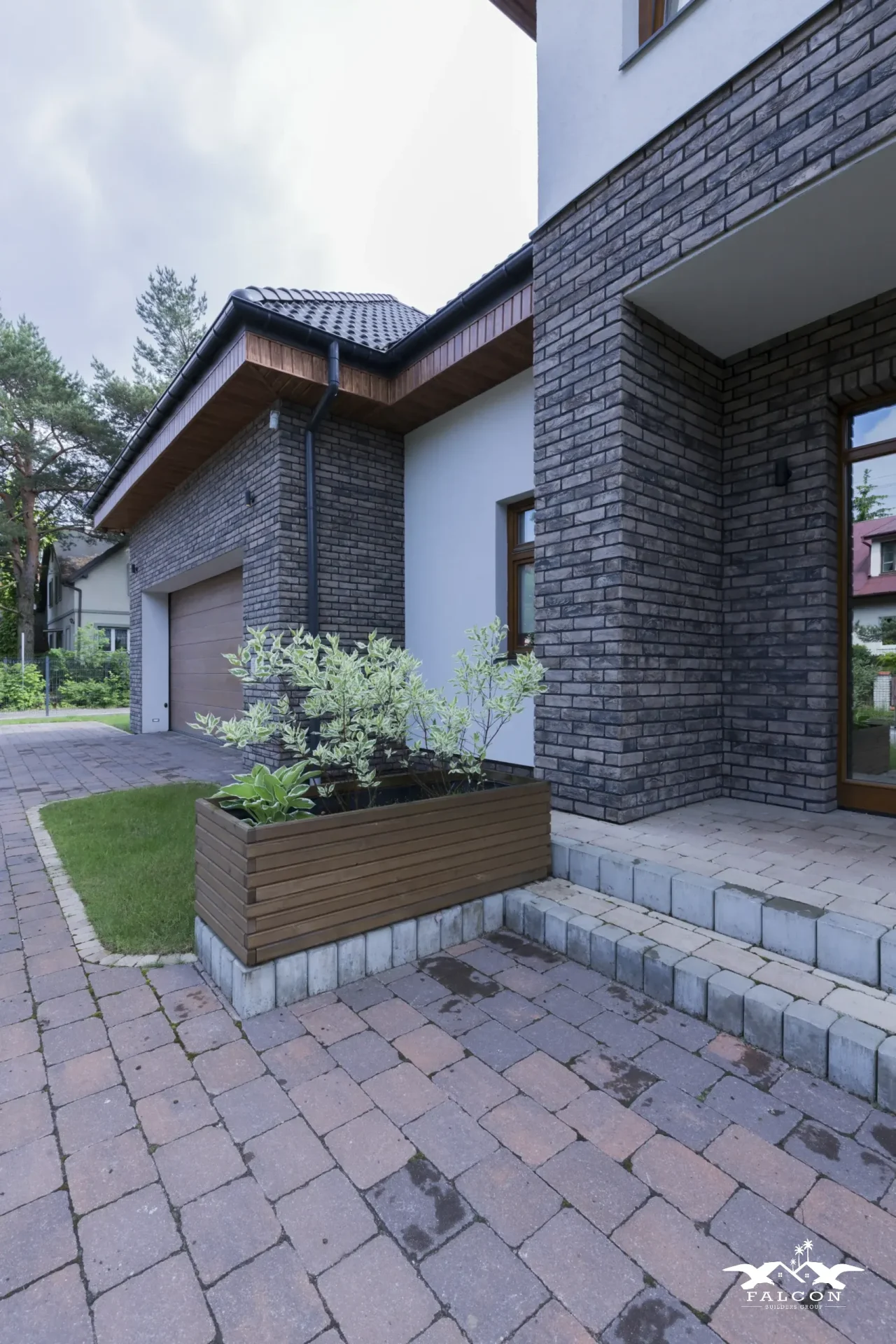 Concrete construction project featuring custom driveway, front walkway, and concrete steps leading to a modern brick home exterior.