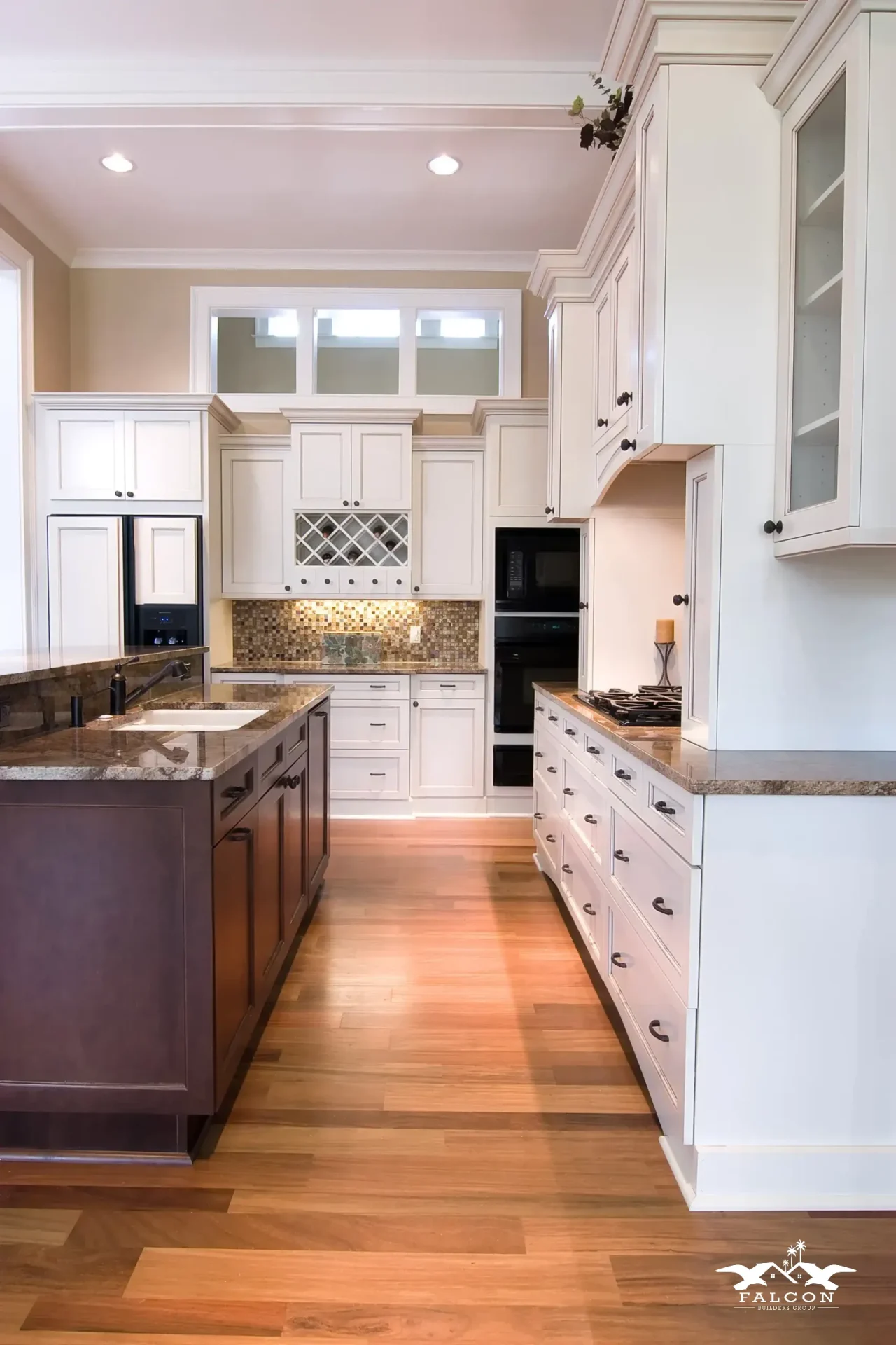 Kitchen remodeling project featuring custom white cabinetry, granite countertops, hardwood flooring, and a modern kitchen island with built-in appliances and storage.