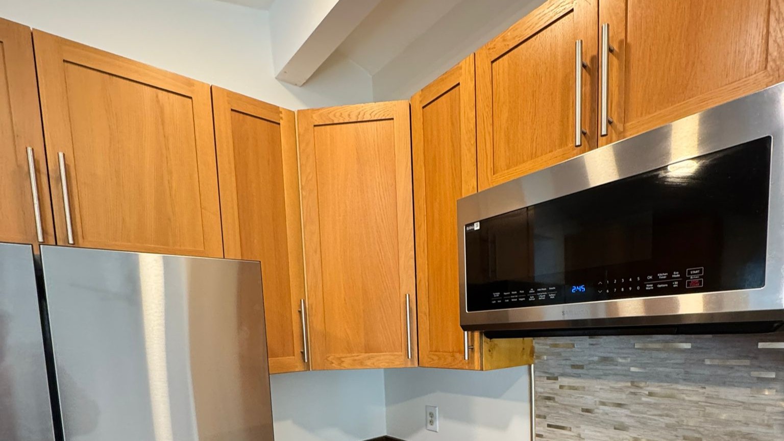 Kitchen remodel San Diego featuring updated cabinets and stainless steel microwave installation